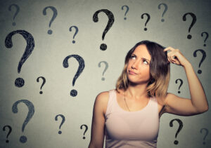 Woman scratching her head with question marks around her