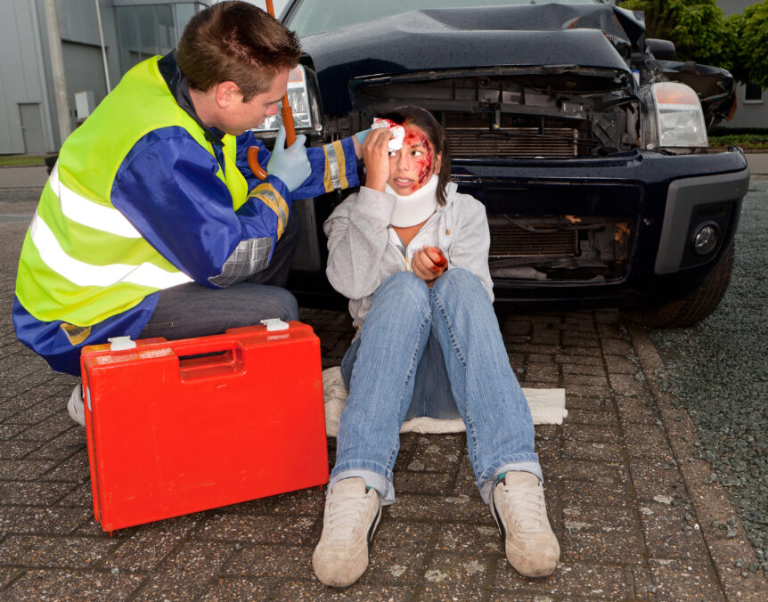 Young woman in neck brace after a car wreck being treated by a medic